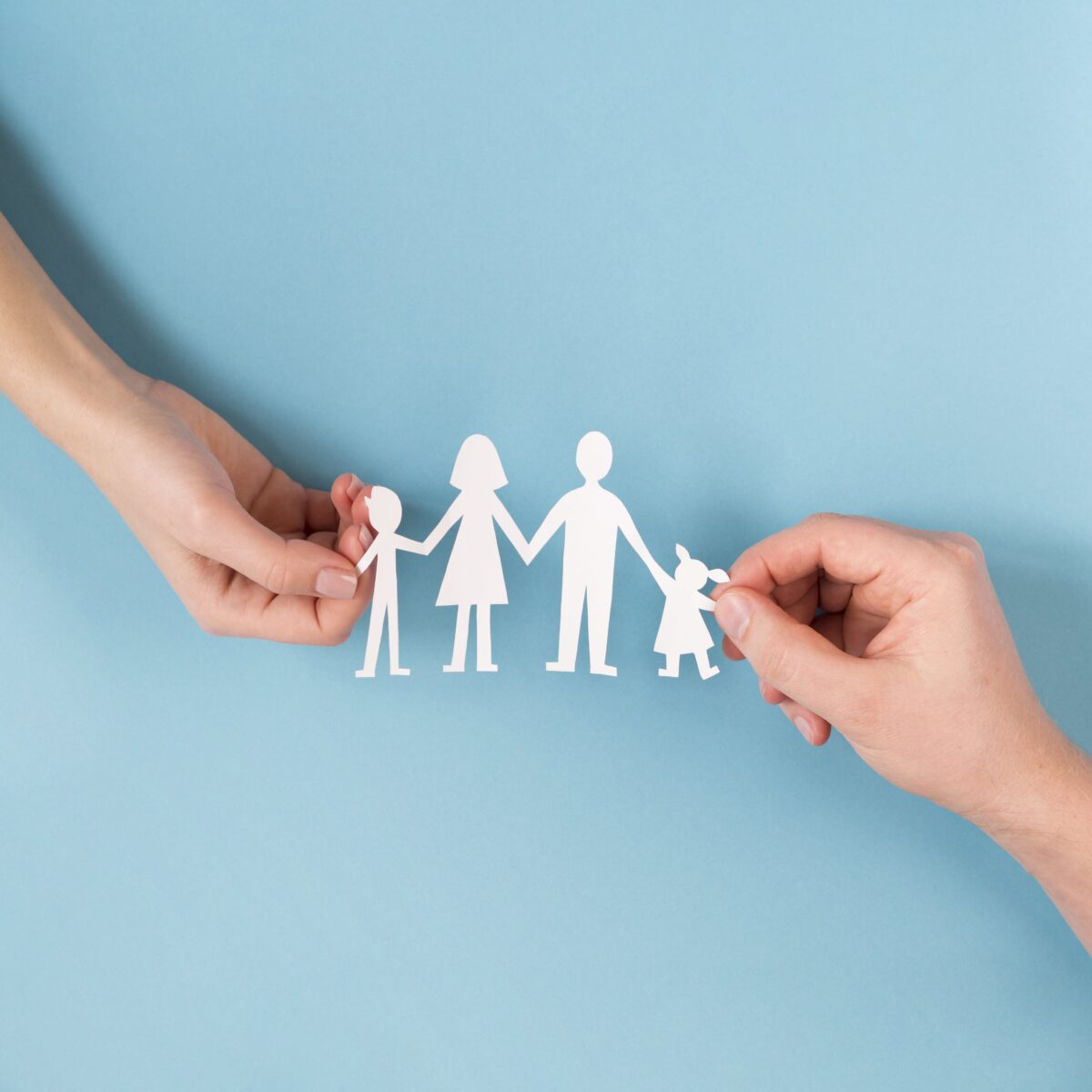 top-view-people-holding-in-hands-cute-paper-family-min
